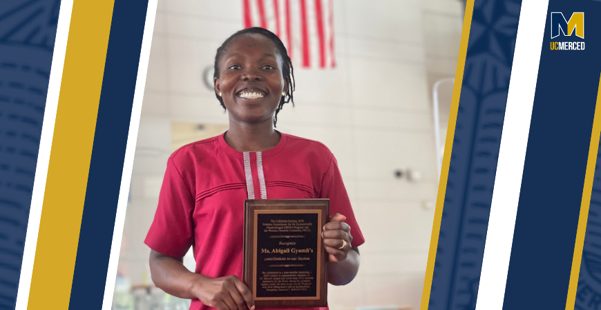Image with blue and gold on either side, female wearing red dress holding a plaque